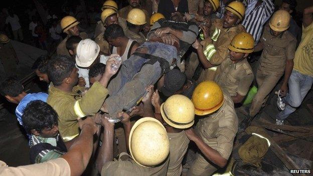 Rescuers carry away injured man on a stretcher after Chennai collapse - 28 June