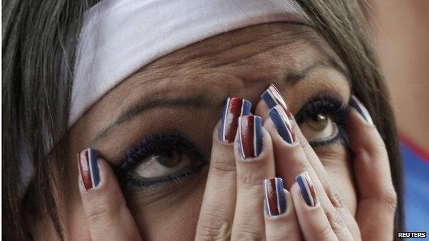 A woman reacts as she watches a screening of 2014 World Cup round of 16 match between Costa Rica and Greece on TV in San Jose on 29 June, 2014.