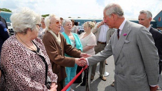 Prince Charles is greeted by 95-year-old Nancy Davies of Llandybie outside the Cnwd factory