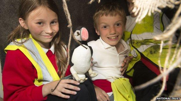 School children hold a puffin toy at the opening of Port y Swnt