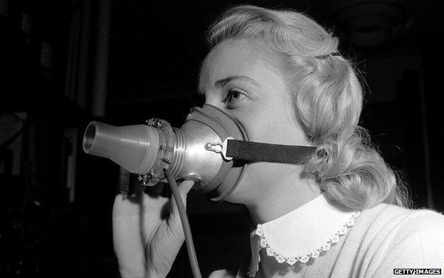 Circa 1955: A woman wears a mask as part of a research programme for hay fever sufferers. Air pressure from the lungs is converted into an electrical current which gives an 'electrical pattern' useful for determining individual responses to pollen