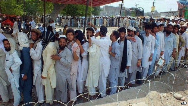 Internally displaced Pakistani tribal civilians, fleeing from military operations against Taliban militants in North Waziristan, queue for relief supplies outside the World Food Programme (WFP) distribution point in Bannu, a town on the edge of Pakistan"s lawless tribal belt of Waziristan on June 26, 2014