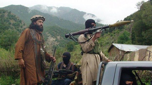 In this file photo taken on Sunday, Aug. 5, 2012, Pakistani Taliban patrol in their stronghold of Shawal in Pakistani tribal region of South Waziristan