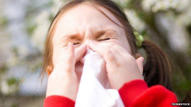 A young girl sneezes