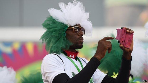 A Nigerian supporter takes a photograph ahead of the football match between Nigeria and Bosnia-Hercegovina on 21 June 2014