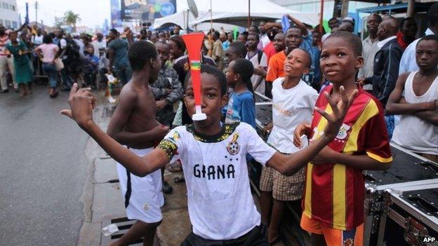 A child poses with a vuvuzela as Ghana supporters react while watching the World Cup 2014 football match between Ghana and Portugal on 26 June 2014 in Accra.