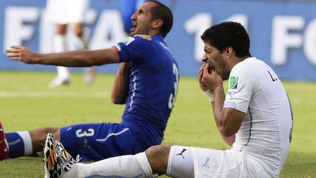 Luis Suarez holds his mouth after clashing with Girgio Chiellini