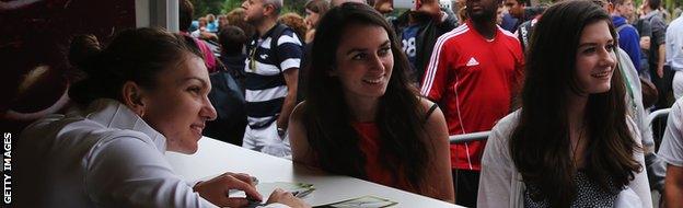 Simona Halep poses for a photo with young fans