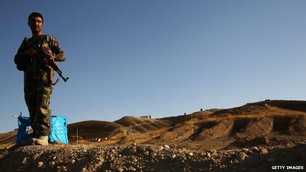 A Kurdish peshmerga soldier keeps guard near the frontline with Sunni militants on the outskirts of Kirkuk (25 June 2014)