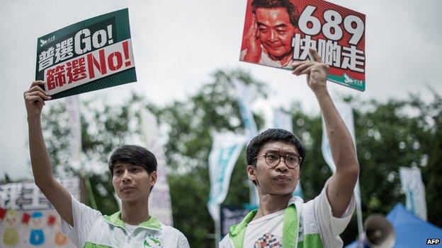 Pro-democracy activists display placards before a pro-democracy rally seeking greater democracy in Hong Kong on 1 July, 2014 as frustration grows over the influence of Beijing on the city