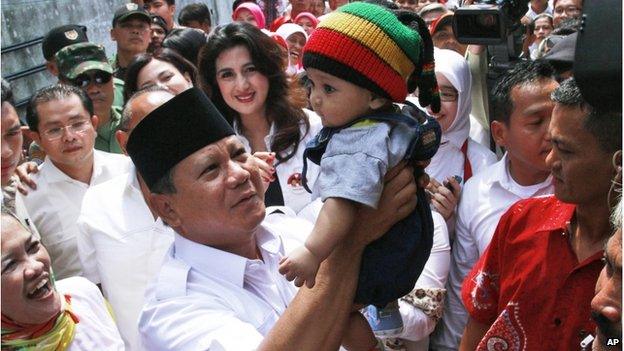 Indonesian presidential candidate Prabowo Subianto (centre) lifts a baby boy during his campaign rally in Bandung, West Java, Indonesia, on 5 June 2014.