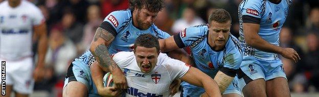 Ashton Sims (l) tackles England's Sam Burgess