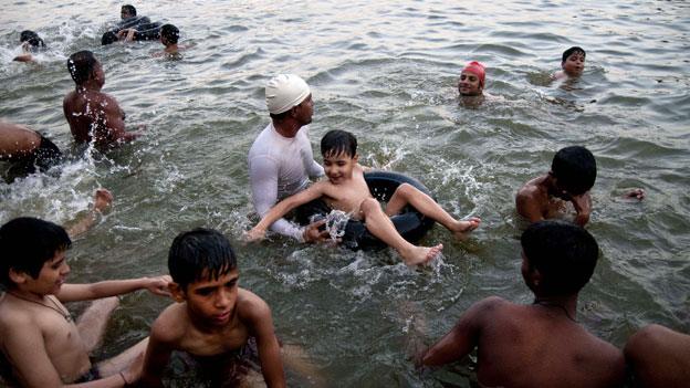 Swimming teacher helping a child learn to swim