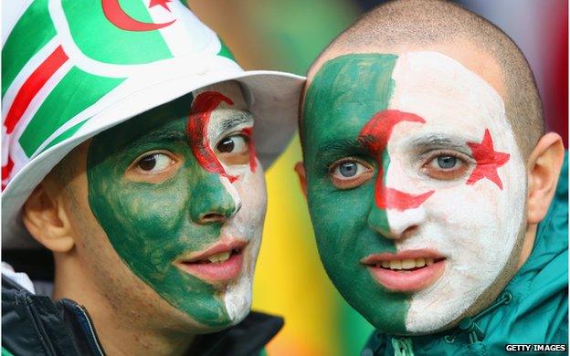 Two Algeria fans with their faces painted as the Algerian flag