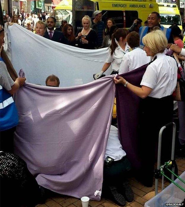 Security staff held up a sheet around the woman to give her privacy as she gave birth