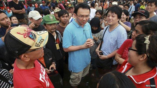 Basuki Tjahaja Purnama talks to residents affected by floods during his visit to Jakarta on 19 January 2013