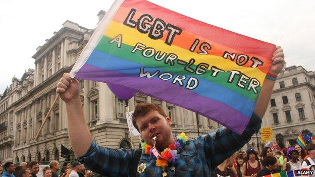 Man holding banner which reads: "LGBT is not a four-letter word"