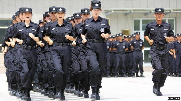 Policewomen from the Special Weapons and Tactics (SWAT) team run in formation during a graduation performance as members of an anti-terrorist patrol team in Xinjiang (June 2014)