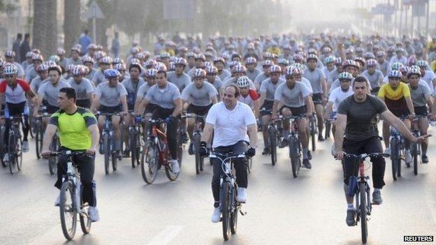 Egypt"s President Abdul Fattah al-Sisi (C, in white) with hundreds of bicycle riders in Cairo on 13 June