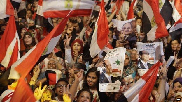 Supporters of Egypt"s president-elect Abdul Fattah al-Sisi wave national flags and his posters after his election win in Cairo on 5 June