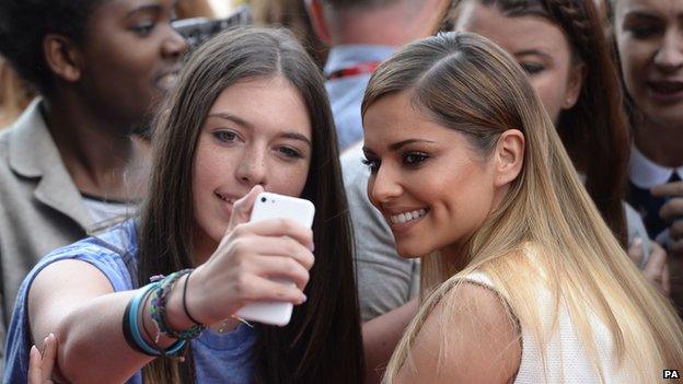 Cheryl Cole takes a selfie with a fan