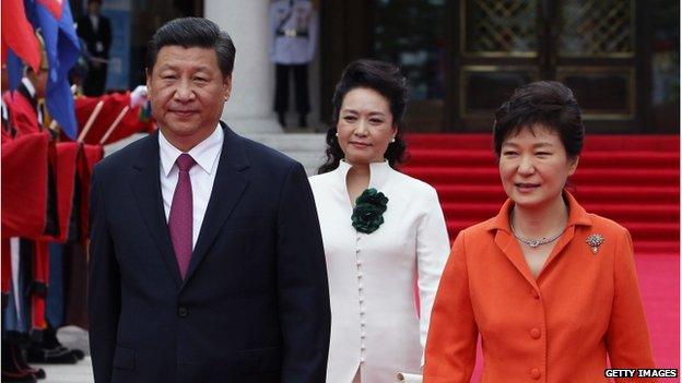 Chinese President Xi Jinping, his wife Peng Liyuan and South Korean President Park Geun-Hye walk towards a guard of honour during a welcoming ceremony held at the presidential Blue House on 3 July 2014 in Seoul, South Korea.