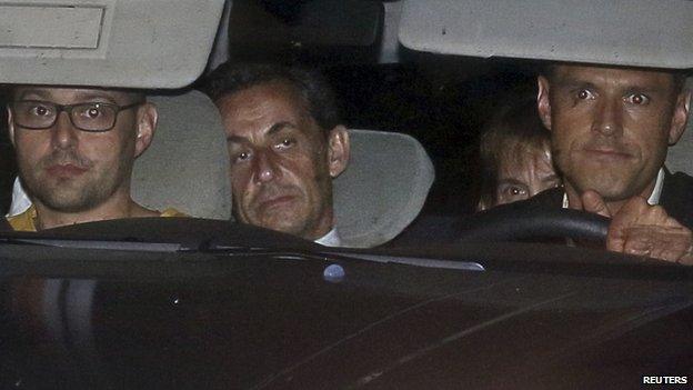 Former French President Nicolas Sarkozy arrives with police by car at the financial investigation unit in Paris to be presented to a judge late 1 July 2014.