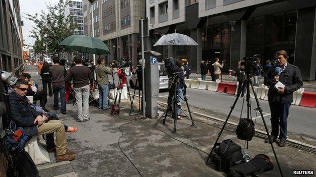 Journalists work in front of the offices of the judicial police in Nanterre, near Paris, on 1 July 2014