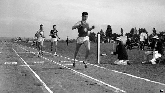 Louis Zamperini of he University of Southern California, breaks the tape and record with a time of 4:16.3 to win the mile run in the Pacific Coast Conference Track and Field meet the University of Washington Stadium in Seattle 20 May 1939