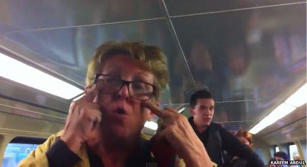 A screengrab from a YouTube video show shows a woman making a slitty eye gesture