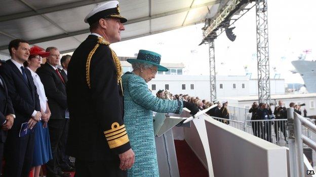 Queen Elizabeth II pressing the button to release the bottle of whisky at Rosyth Dockyard, Fife to formally name the Royal Navy's biggest ever ship, HMS Queen Elizabeth