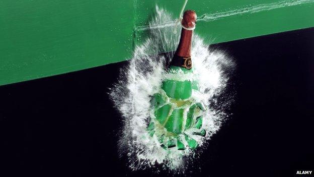 A bottle of champagne smashing against a ship