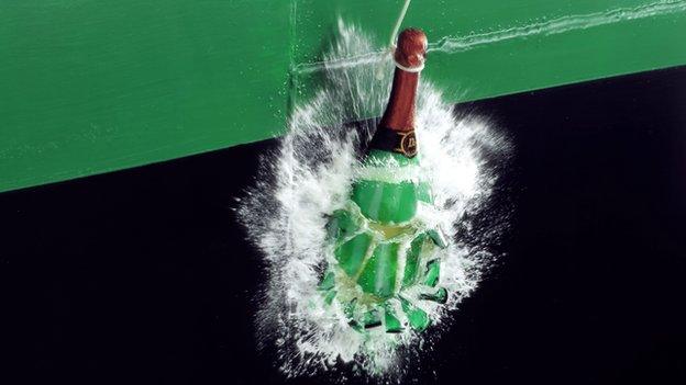 A bottle of champagne smashing against a ship