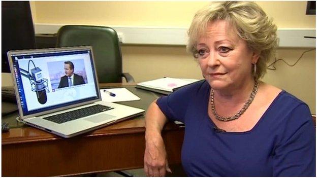 Ann Barnes in front of picture of David Cameron