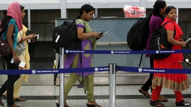 Some of the Indian nurses, held hostage by Islamic militants in Iraq, queue at the airport in the autonomous Kurdistan region of northern Iraq before flying home (4 July 2014)