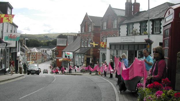 People line the street carrying the scarp