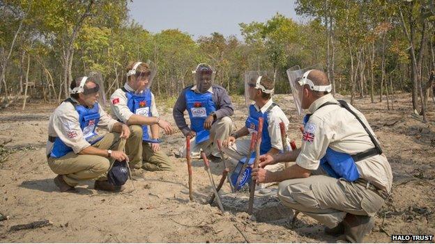 Five men crouching and wearing protective equipment