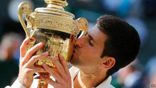 Djokovic kissing the Wimbledon trophy