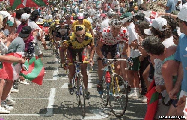 A fan sprays water on Frenchman Richard Virenque, wearing the red and white Polka Dot Jersey of the best climber, during the Port de Larrau Pass climb, 1996