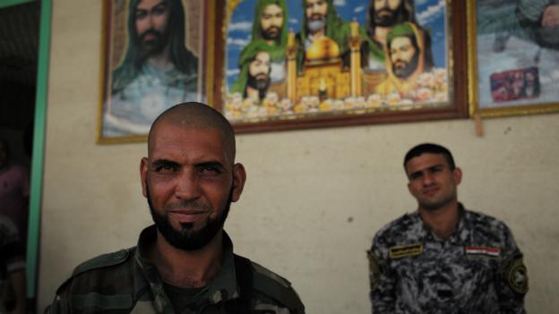 Two members of Asaib Ahl al-Haqq stand outside their headquarters north of Baghdad - July 2014