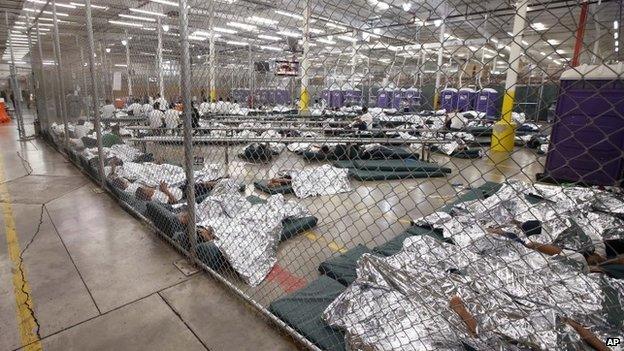 Detainees sleep and watch television in a holding cell where hundreds of mostly Central American immigrant children are being processed and held at the US Customs and Border Protection Nogales Placement Center Nogales, Arizona 18 June 2014