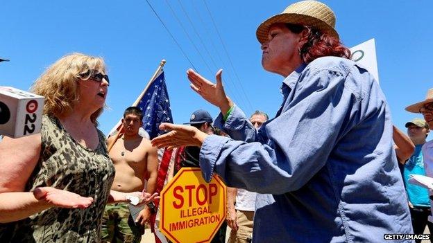 Anti-immigration activist Sabina Durden (R) and immigration sympathizer Mary Estrada (L) debate during a protest outside of the US Border Patrol Murrieta Station 7 July 2014