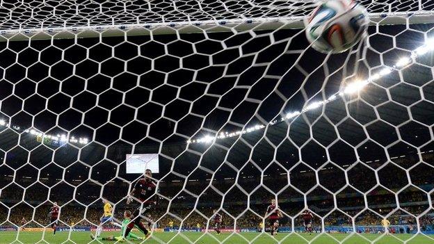 Brazil"s midfielder Oscar (L) scores against Germany"s goalkeeper Manuel Neuer during the semi-final football match between Brazil and Germany at The Mineirao Stadium in Belo Horizonte