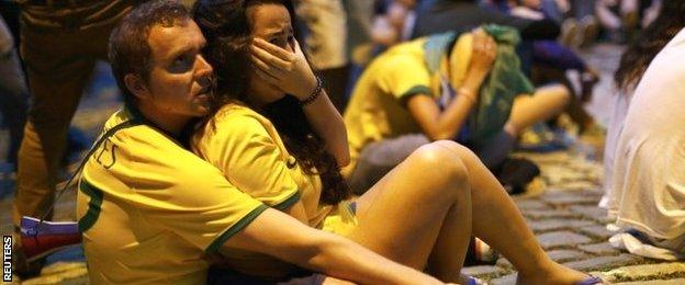 Brazil fans react as they watch their 2014 World Cup semi-finals against Germany on a street in Rio de Janeiro