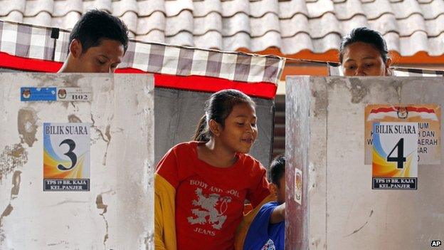 Children wait for their parents voting in the presidential election in Bali, Indonesia, on 9 July 2014