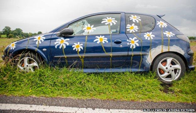 Abandoned Peugeot car painted with daisies