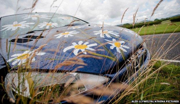 Abandoned Peugeot car painted with daisies