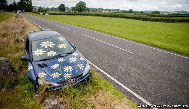 Abandoned Peugeot car painted with daisies