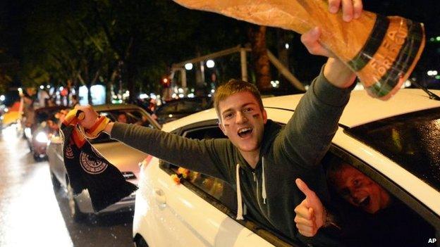 Soccer fans celebrate with a mock World Cup trophy in Dusseldorf, Germany