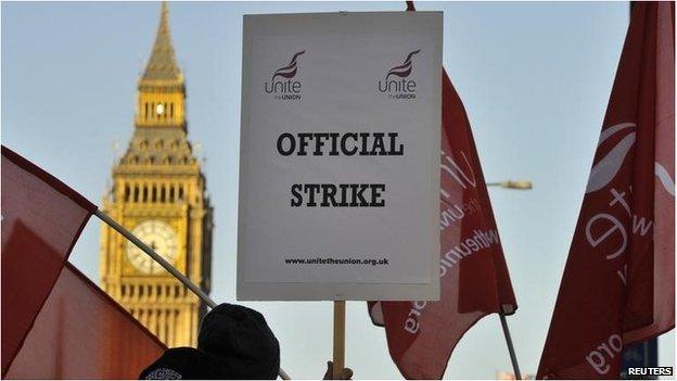 A worker on strike holds a placard saying "Official strike", with Big Ben visible in the background